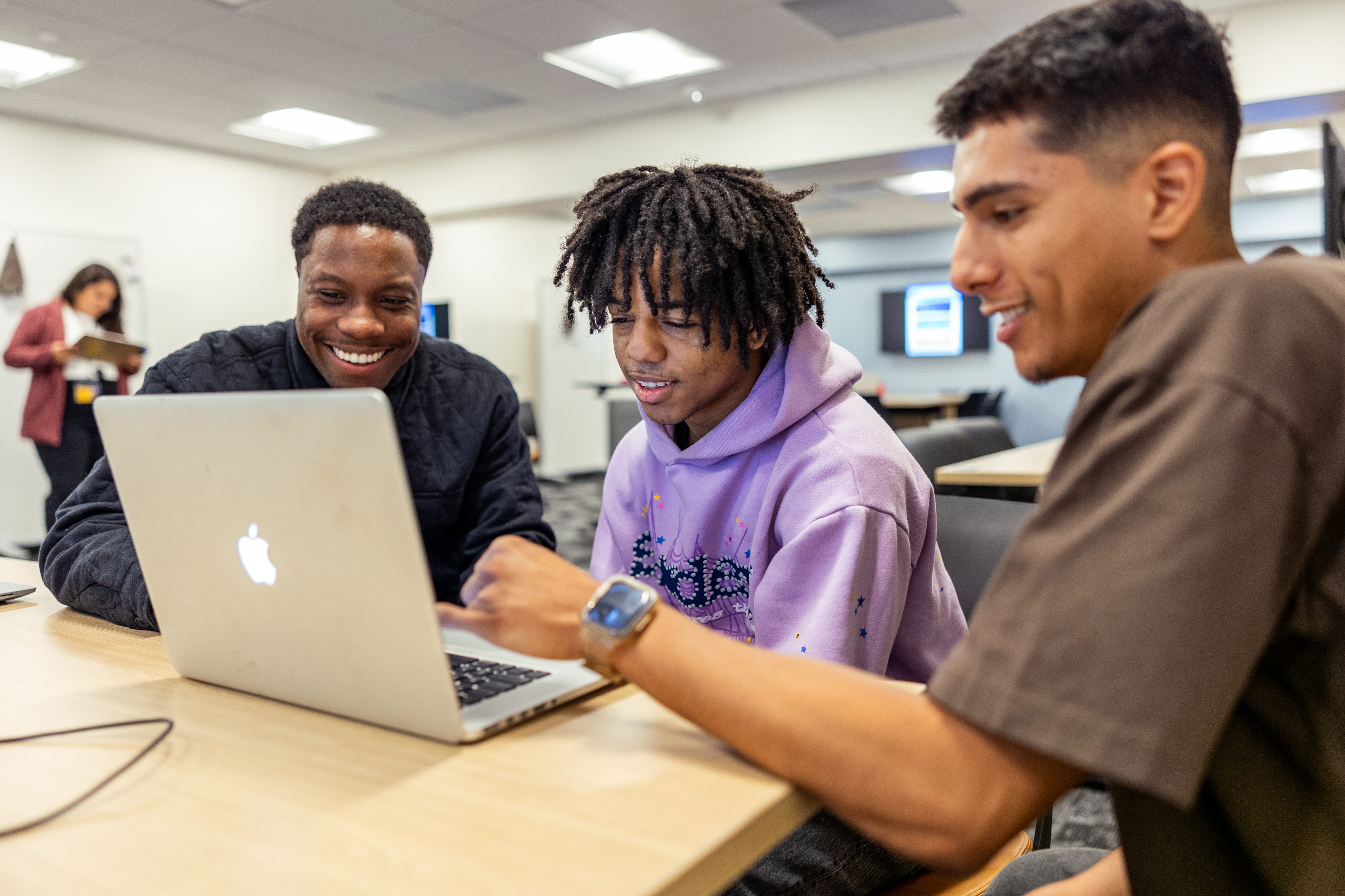 Students looking at a computer in classroom